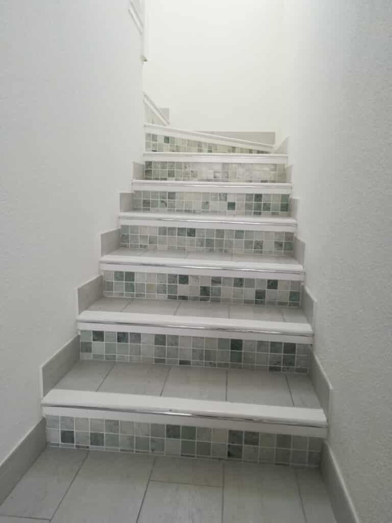 Coastal house stairs renovation with tiling and silver frame