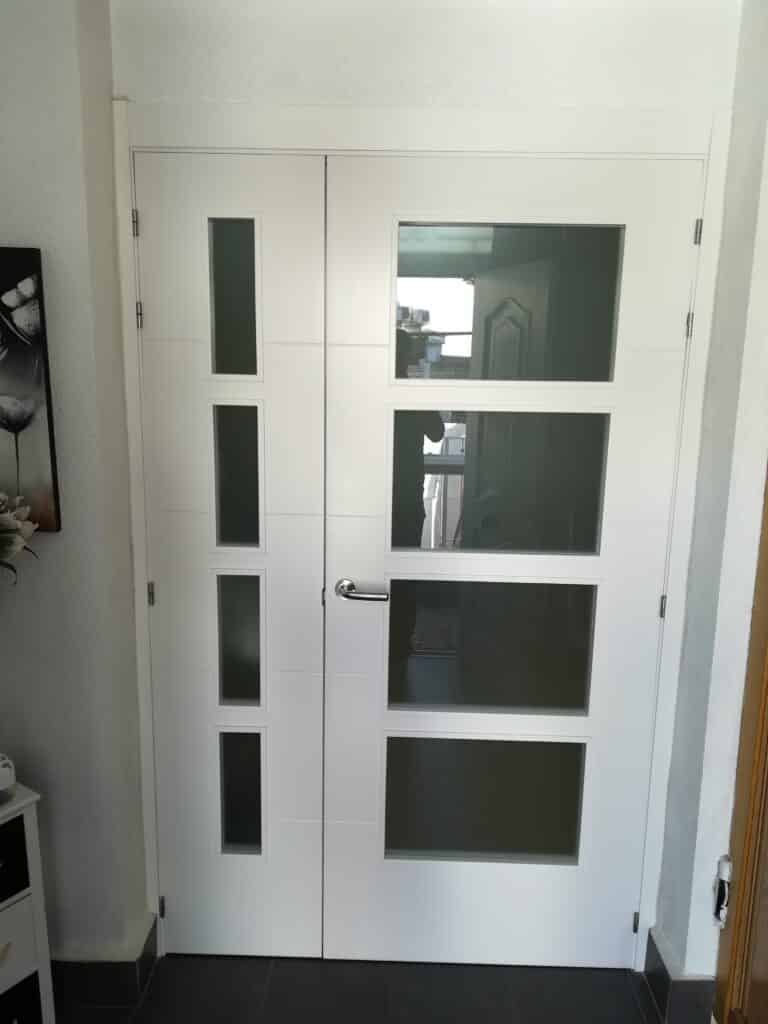 Installation of a white door with glass in a home renovation