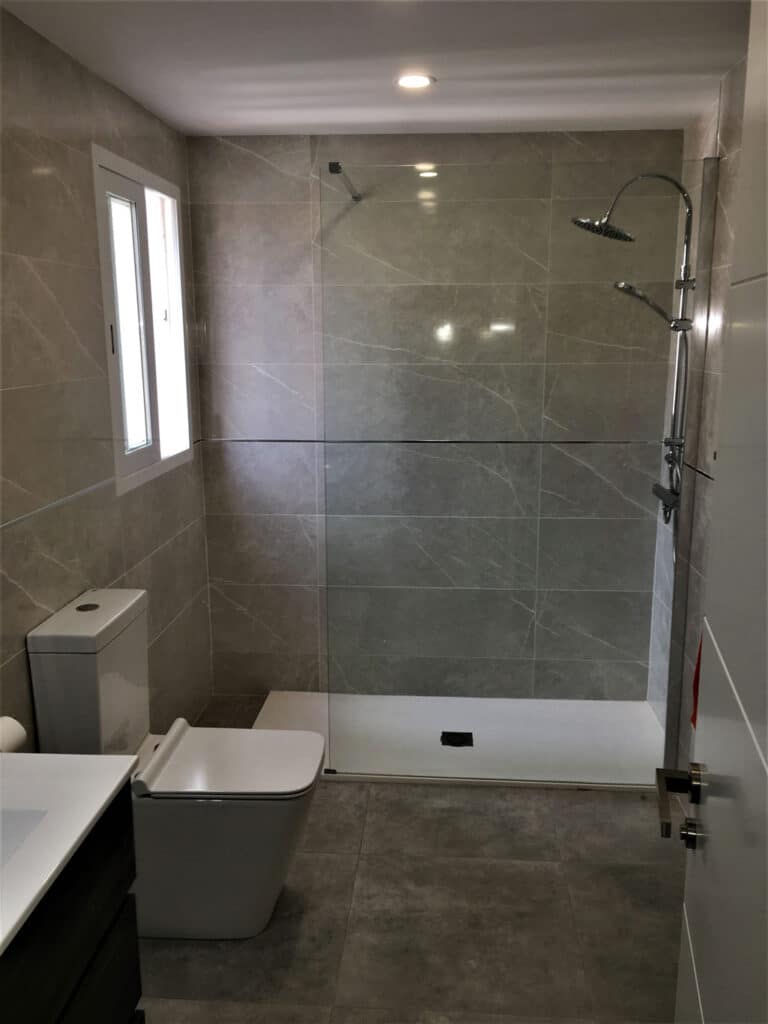 Spacious bathroom renovation in modern style with glass screen installation