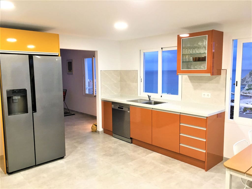 Orange kitchen renovation with large refrigerator