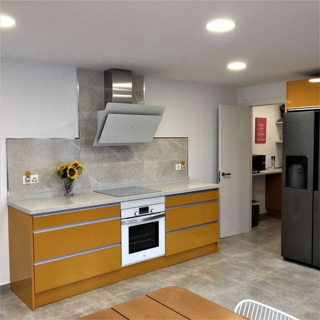 Orange kitchen cabinets and tiling with silver frame